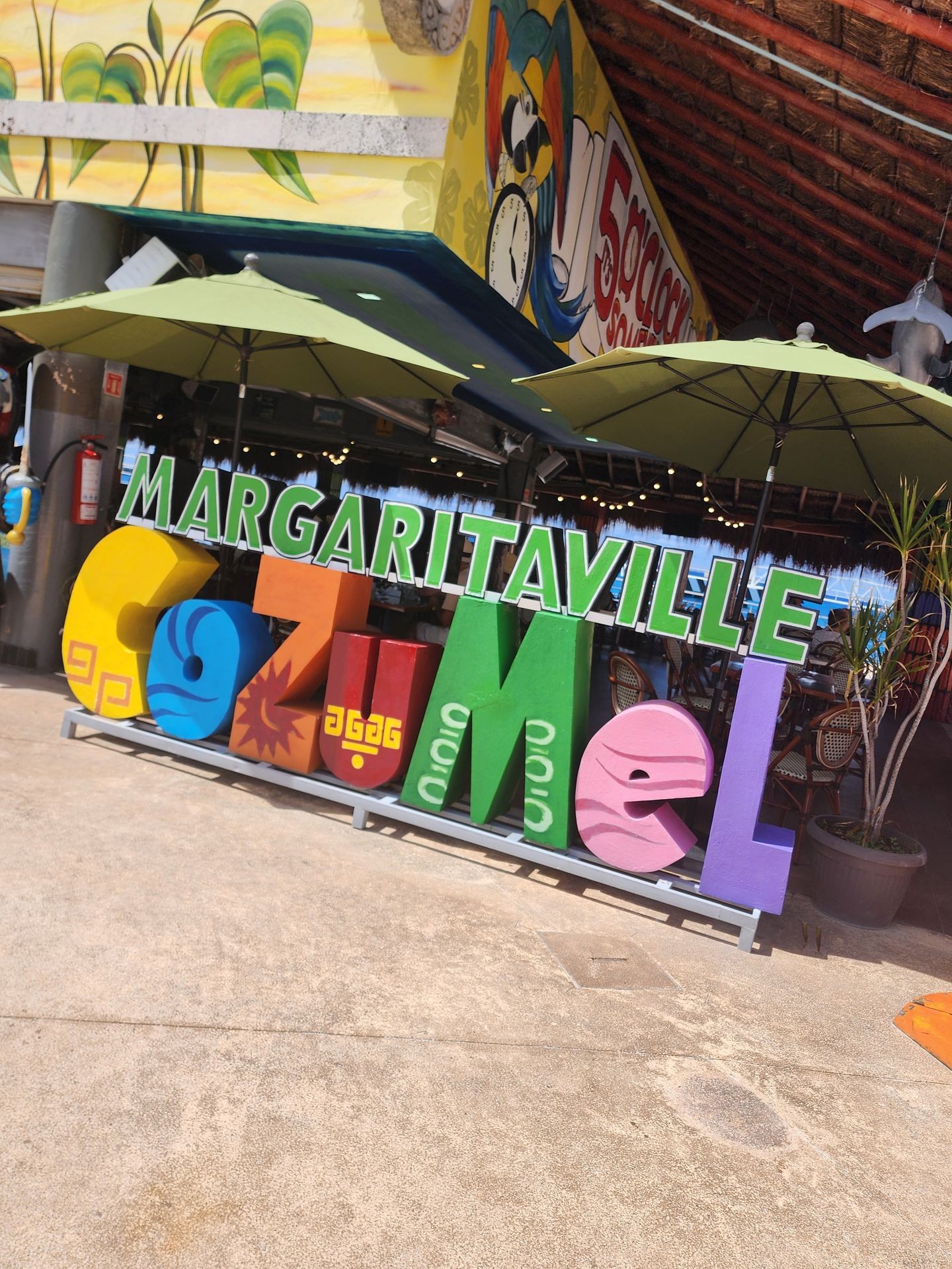 Colorful Margaritaville Cozumel sign with umbrellas and tropical-themed decoration.